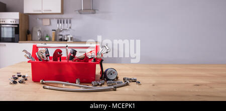 Toolbox mit unterschiedlichen Worktools auf hölzernen Schreibtisch Stockfoto