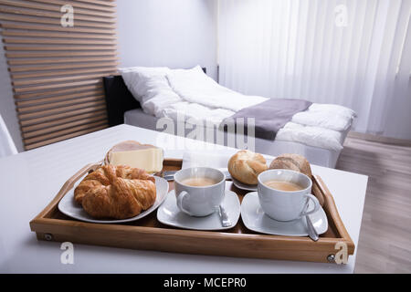Frische Croissants und Tasse Tee in Holz- Fach zum Frühstück Stockfoto