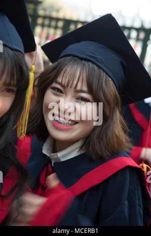 Ein Mädchen mit einem roten und schwarzen Gewand und der Kappe an Ihre Abschlussfeier im Tempel der Literatur in Hanoi, Vietnam, Südostasien Stockfoto