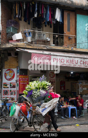 Eine Frau, die den Verkauf von Trauben von Schnittblumen in der Altstadt von Hanoi, Vietnam, Südostasien Stockfoto