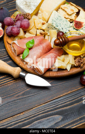 Camembert Käse und Prosciutto mit Honig, Feigen, Walnüsse auf Holzbrett Stockfoto