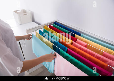 Nahaufnahme von einer Frau Hand Hängende Kleidung auf die Wäscheleine Stockfoto