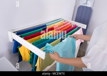 Nahaufnahme von einer Frau Hand Hängende Kleidung auf die Wäscheleine Stockfoto