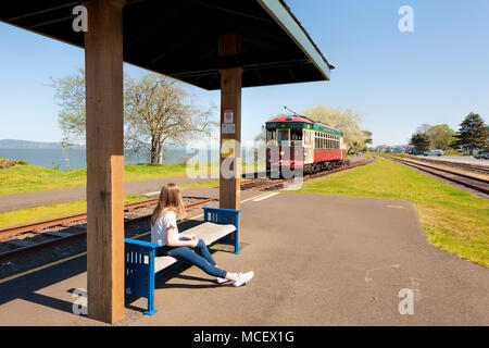 Astoria, Oregon, USA - April 7, 2016: Ein junges Mädchen wartet an einer Haltestelle des Trolley am Columbia River in den Astoria, Oregon Küste zu fahren, Stockfoto