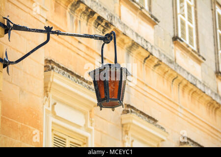 Mdina, Malta Insel. Alte Laterne Lampe in der mittelalterlichen Stadt mit den engen Gassen und Häuser Sandsteinfassaden Stockfoto