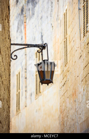 Mdina, Malta Insel. Alte Laterne Lampe in der mittelalterlichen Stadt mit den engen Gassen und Häuser Sandsteinfassaden Stockfoto