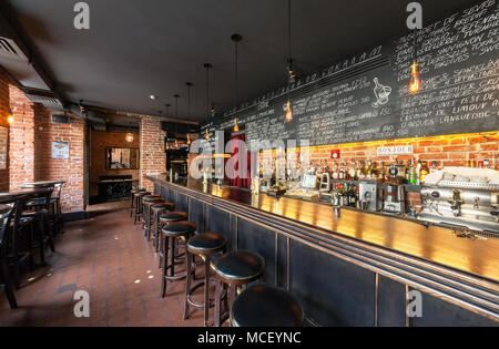 Moskau - AUGUST 2014: Der Innenraum der Wein Bar 'GAVROCH'. Langen hölzernen Tresen mit Barhockern und ein großes Menü auf der Schiefertafel board Stockfoto