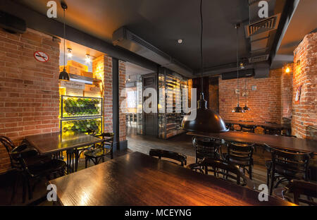 Moskau - AUGUST 2014: Der Innenraum der Wein Bar 'GAVROCH'. Halle im Loft-Stil mit gemauerten Wänden, Holzmöbeln, Wine Rack- und gedämpften Licht Stockfoto