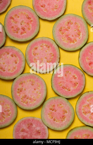 Blick von oben auf die Scheiben von Pink Guave auf gelbem Hintergrund Stockfoto