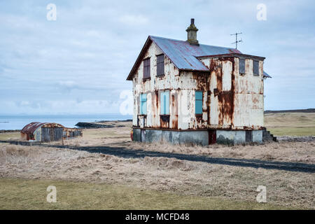 In der Nähe von Reyjanes Garður auf der Halbinsel, Island. Alten Wellblech Gebäude an einer verlassenen Farm an der Küste. Stockfoto