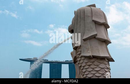 Das fließende Wasser Auslauf der Sehenswürdigkeiten Singapur Merlion mit Marina Bay Sands im Hotel im Hintergrund. Stockfoto