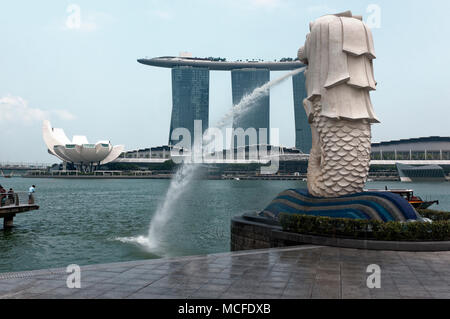 Das fließende Wasser Auslauf der Sehenswürdigkeiten Singapur Merlion mit Marina Bay Sands im Hotel im Hintergrund. Stockfoto