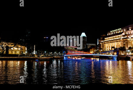 Singapore River in der Nacht, mit der Fullerton Hotel und Cavenagh Brücke beleuchtet und reflektiert Stockfoto