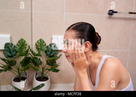 Junge schöne asiatische Frau waschen Ihr Gesicht mit den Händen von Soap Stockfoto