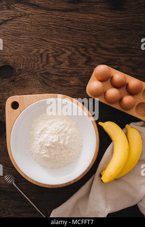 Die Zutaten für die Banane Kuchen Mehl Ei auf Holztisch. Stockfoto