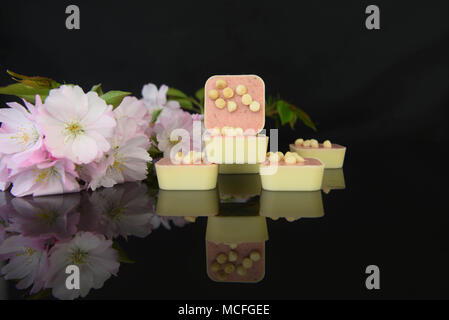 Lassen Sie sich mit weißer Schokolade und roten Beeren Trüffel mit frischen Blumen Stockfoto