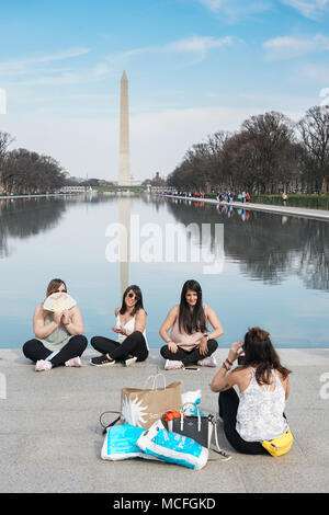 Touristen, die Fotos vor dem Washington Monument auf der National Mall in Washington DC in den Vereinigten Staaten. Aus einer Reihe von Fotos Stockfoto