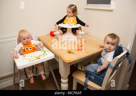 Babys und Kleinkinder mit einem Snack im Kindergarten, Großbritannien Stockfoto