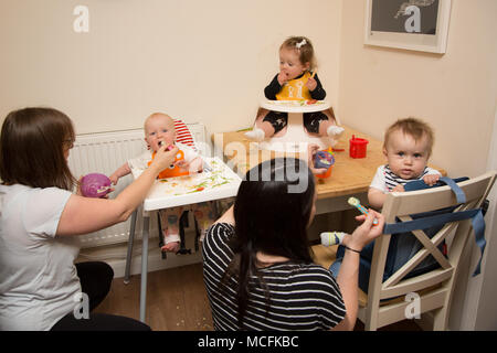Babys und Kleinkinder mit einem Snack im Kindergarten, Großbritannien Stockfoto