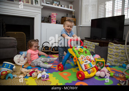 Babys, die mit ihren Spielsachen spielen. Stockfoto