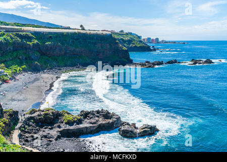 PUERTO DE LA CRUZ, TENERIFFA - 24. MÄRZ 2018: Touristen genießen Urlaub Sonnen in einem beliebten Ferienort im Norden von Teneriffa berühmt für seine dunklen volc Stockfoto