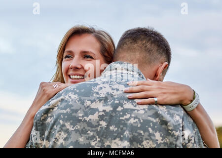 Blick nach hinten, Reifen Soldat ist das Umarmen mit seiner Frau. Wiedervereinigung der Reifes Paar, Mann kam zurück von der Armee. Stockfoto