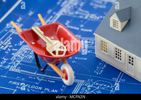 Blueprints mit einem Modell Haus und Wheel Barrow mit Schlüssel. Stockfoto