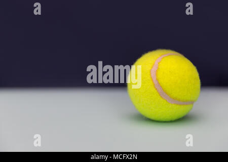 Gelbe Tennisball auf dunklem Hintergrund mit Kopie Raum Stockfoto