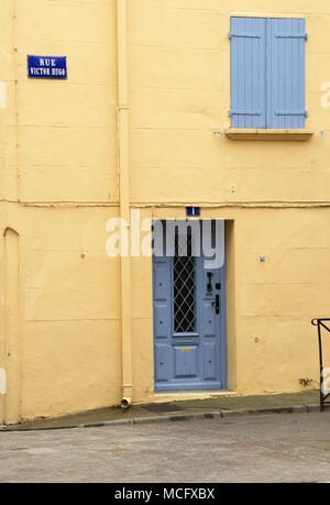 Haus in Céret, mit Gelb gestrichene Wand und blauen Fensterläden und die vordere Tür, Rue Victor Hugo, Pyrénées-Orientales, Region Occitaine, Südfrankreich. Stockfoto