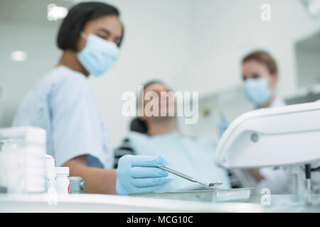 Qualifizierten weiblichen Zahnarzt Holding ein Instrument Stockfoto