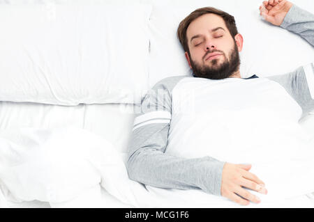 Hübscher junger Mann schlafen im Bett Stockfoto