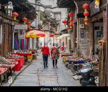 Chinesische Touristen schlendern Sie zu den Geschäften und Ständen von Daxu Markt. Billig Schmuck, Andenken und Schmuck säumen die Straße. Daxu, China. Stockfoto