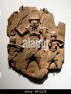 Berlin. Deutschland. Benin Bronzen. Hochrangige Würdenträger mit Schwert und rechteckigen Bell durch zwei hornbläser, Messingschild begleitet. 16./17. Jahrhundert. Stockfoto