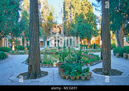 MAHAN, IRAN - Oktober 16, 2017: vakil-ol-molki Innenhof von Shah Nematollah Vali Schrein verfügt über einen malerischen Garten mit Teich und viele Töpfe von Blumen ein Stockfoto