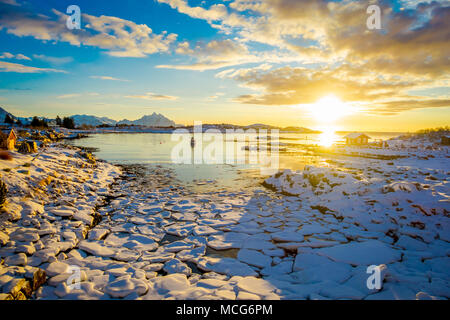 Tolle Aussicht auf den Sonnenuntergang mit kleinen und mittleren Stücke Eis hinter während der Ebbe auf einem zugefrorenen See links Stockfoto