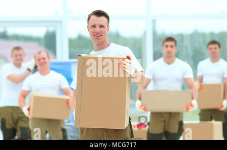 Meister und Arbeiter mit Boxen von Baustoffen Stockfoto