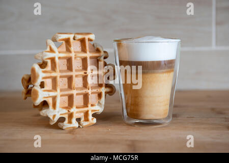 Glas Tassen multilayer Kaffee mit Mini stroopwafel, syrupwaffles Cookies auf hellgrauem Hintergrund mit Kopie Raum. Waffel cookies Stockfoto