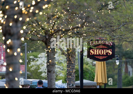 Outdoor Dining und Gehweg unter beleuchtete Bäume entlang der Geschäfte und Baum - Hauptstraße in Lilburn, Georgien gesäumt. Stockfoto