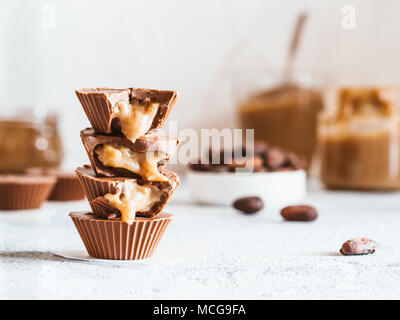Stapel von vegane Schokolade Tassen mit Karamell auf weißen Tischplatte. Hausgemachte vegetarische Chocolate Caramel Cups mit rohem Kakao Schokolade. Ideen und Rezepte f Stockfoto