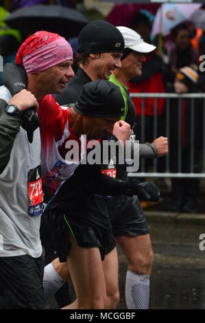 Boston, MA, USA April 16, 2018 Marathoin Läufer helfen einem verletzten Läufer, als er die Ziellinie der Boston Marathon Credit: James Kirkikis/Alamy Leben Nachrichten apprpoacjhes Stockfoto