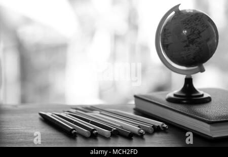 Ein Stift auf dem Schreibtisch mit kleinen Globus Stockfoto