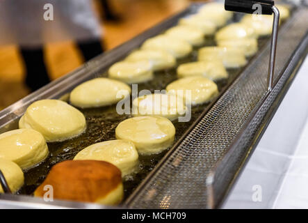 Die hausgemachte Marmelade Donuts in einem professionellen Restaurant Buffet Küche. Frittieren Donuts in heißem Öl im Restaurant Ofen oder Friteuse. Stockfoto