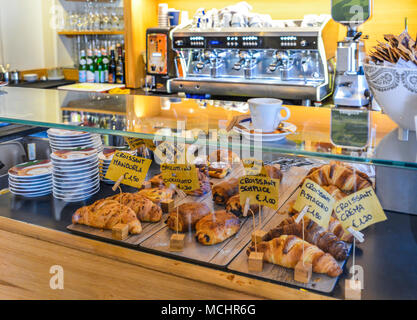 Ein italienisches Frühstück mit verschiedenen Aromen von Croissant. Kaffeemaschine im Hintergrund. Stockfoto