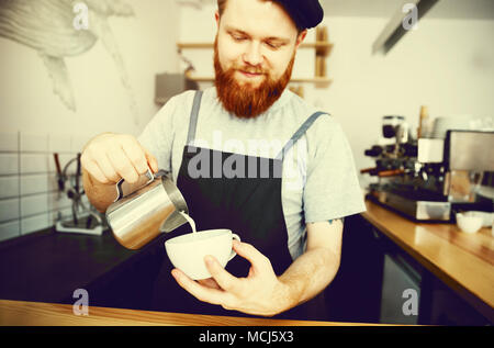 Kaffee Business Konzept - gut aussehender bärtiger Mann im Vorfeld Kaffee im Stehen im Cafe Stockfoto