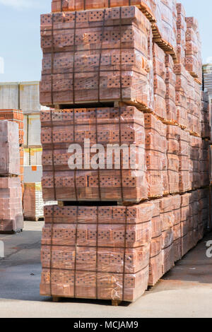 Mehrere Paletten mit Beton Ziegel übereinander im Depot gestapelt. Neue Ziegel auf Paletten. Stockfoto