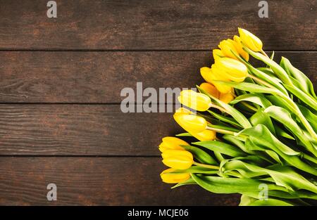 Gelbe Tulpen auf hölzernen Hintergrund Stockfoto