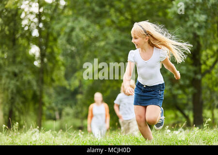 Gerne blonde Mädchen läuft schnell über eine Wiese und Spaß haben Stockfoto