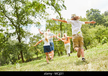Glückliche Familie und Kinder spielen urkomisch auf einer Sommerwiese Stockfoto