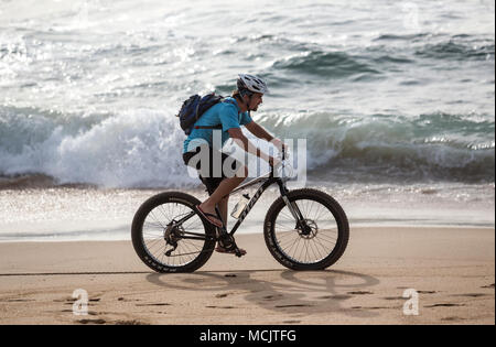 Durban, Südafrika, April 9 - 2018: Mann, Fahrrad am Strand entlang. Stockfoto