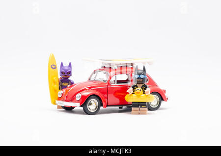 Mini Abbildung von bat Girl und Batman auf Urlaub mit Volkswagen Käfer. Lego Minifiguren sind von der Lego Gruppe hergestellt. Stockfoto